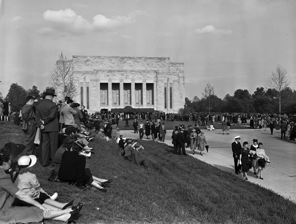  Black and white photograph of people gathered outside in a large square. 