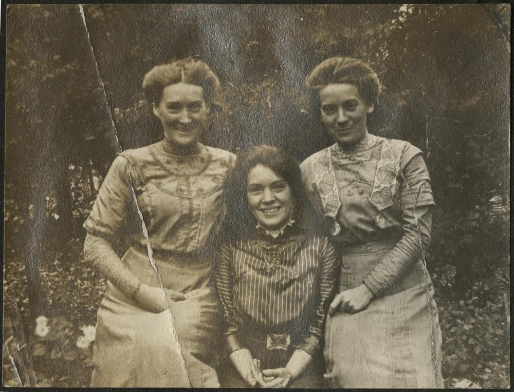  Black and white photograph of three women posing next to each other. 